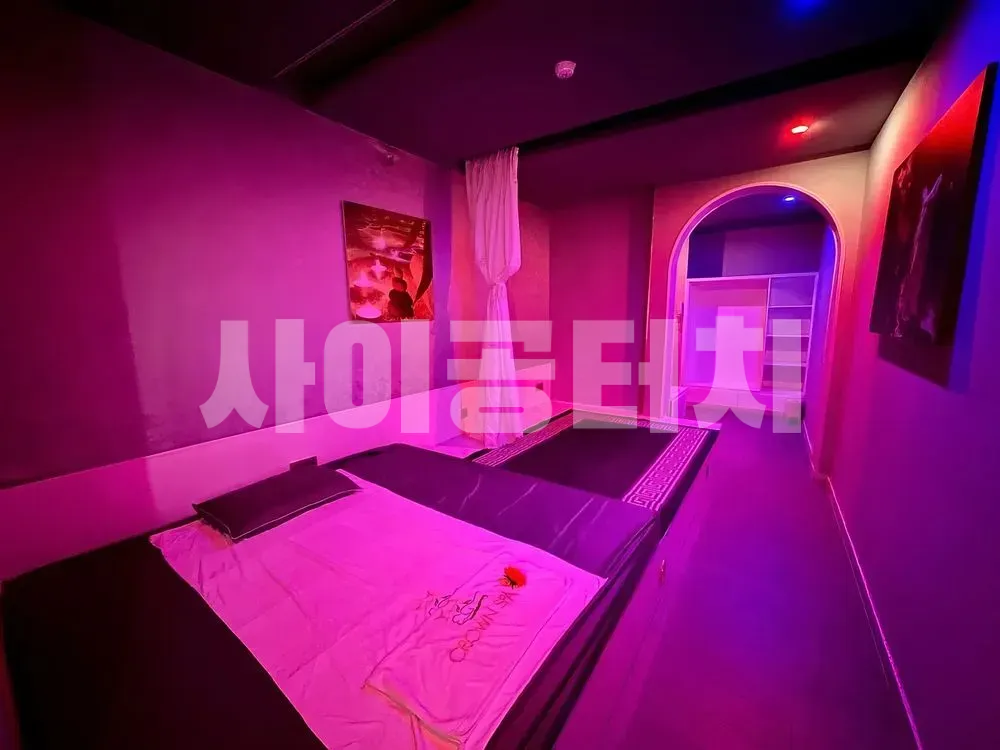 보라색 조명 아래의 2인용 마사지 룸