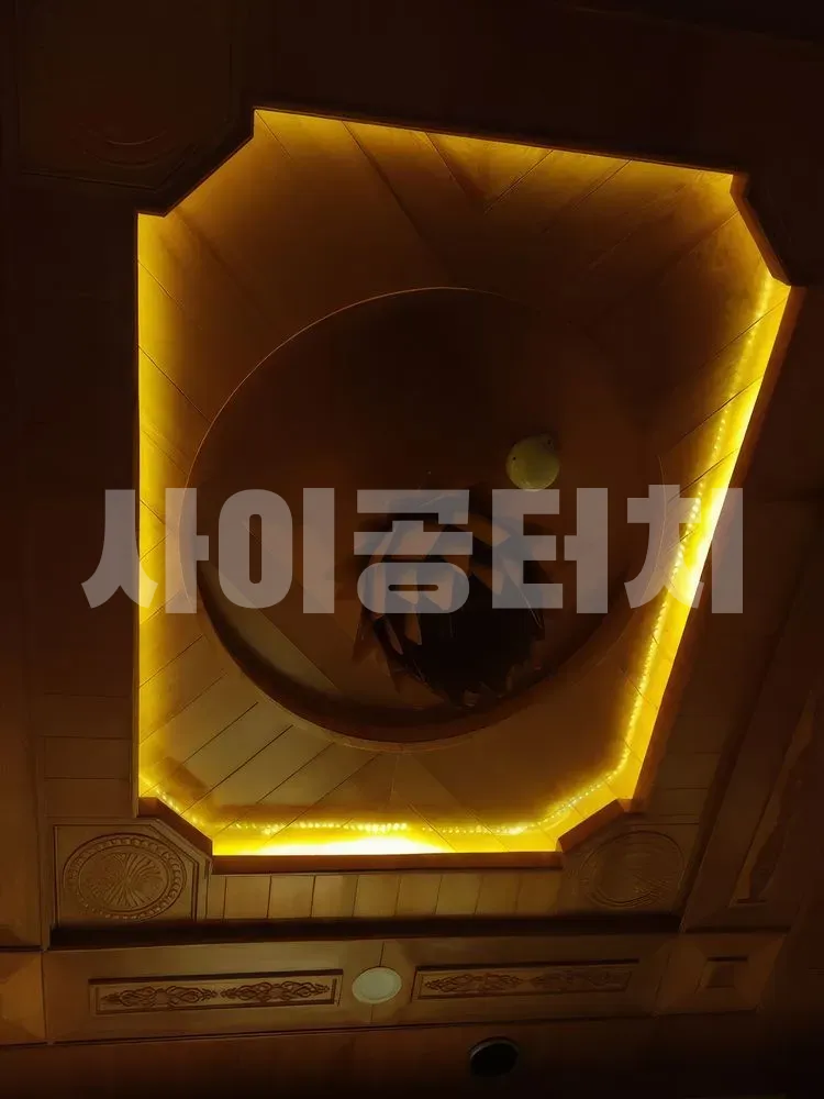 노란 조명이 빛나는 팔각형 나무 천장