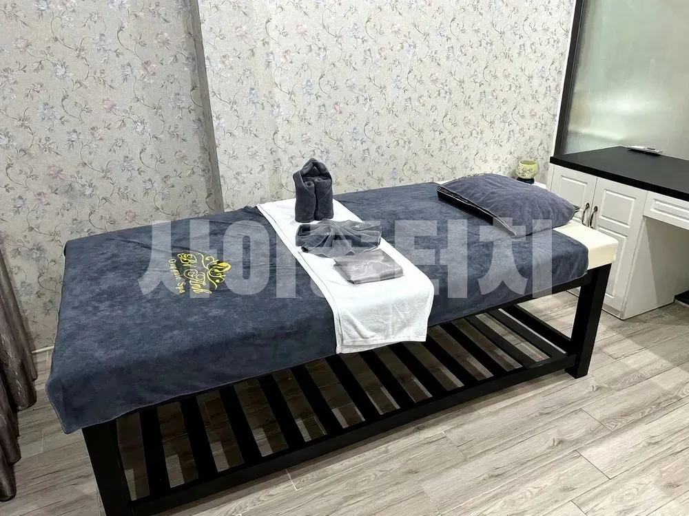 꽃무늬 벽지 방의 마사지 베드