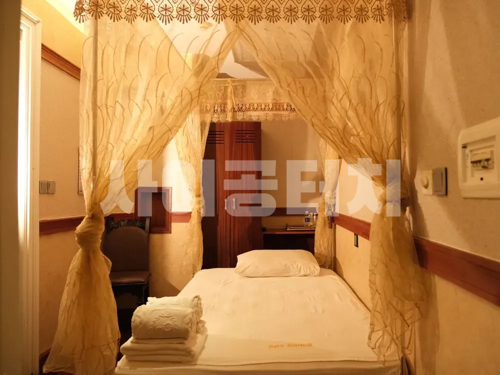 옅은 색 캐노피가 설치된 아늑한 분위기의 룸