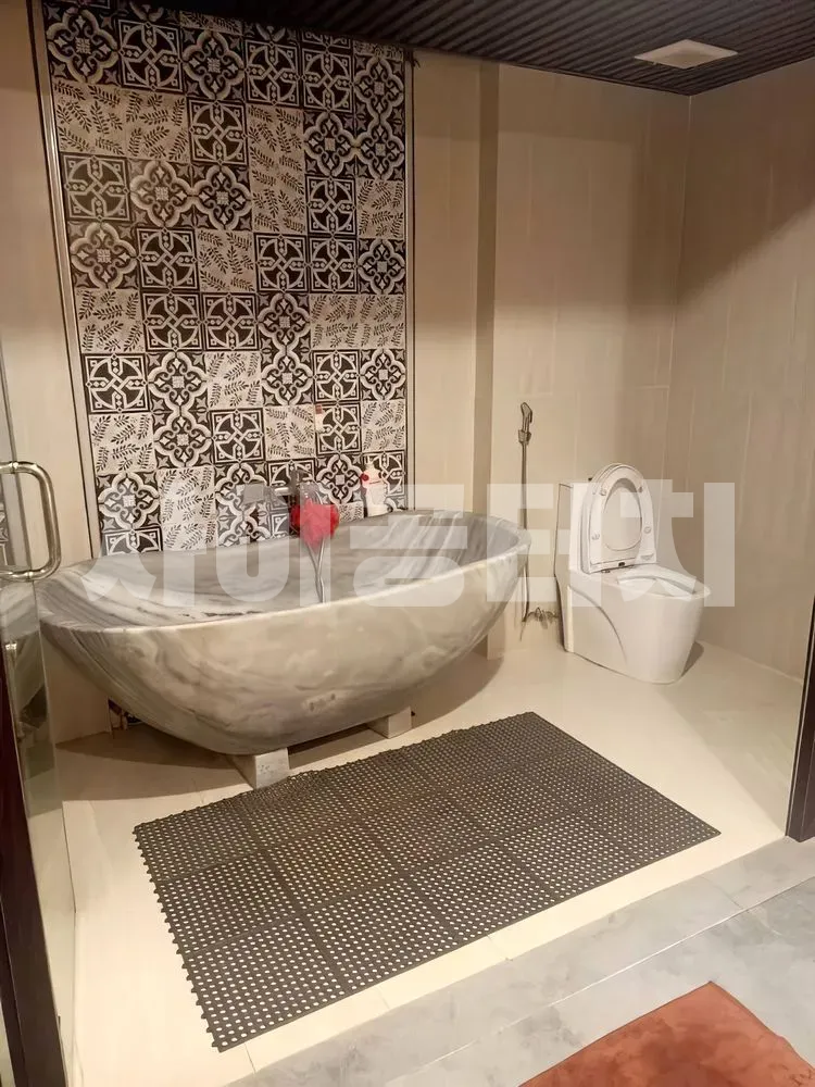 대리석 욕조와 흑백 패턴 타일의 욕실