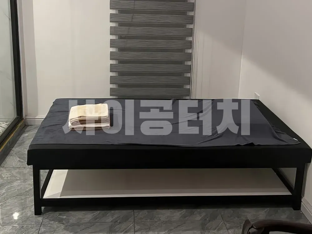 깔끔하게 정리된 검은색 마사지 베드