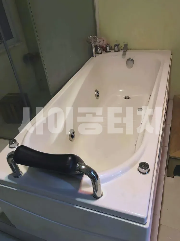 손잡이가 달려있는 깨끗한 흰색 욕조